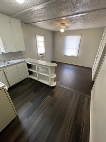 kitchen with sink, range, white cabinets, and dark hardwood / wood-style floors