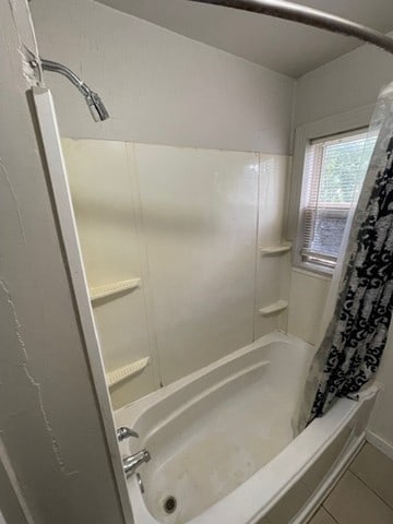 bathroom featuring shower / bath combination with curtain and tile patterned floors