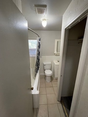 full bathroom featuring tile patterned flooring, vanity, shower / bath combination with curtain, and toilet