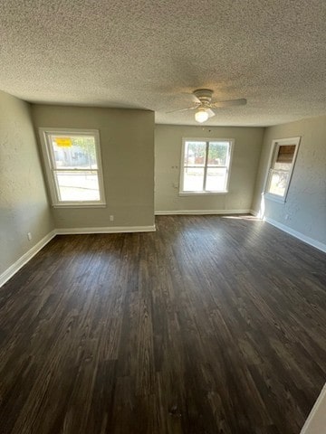 empty room with dark hardwood / wood-style floors, a textured ceiling, and ceiling fan