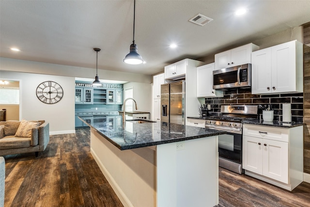 kitchen featuring sink, appliances with stainless steel finishes, white cabinetry, an island with sink, and decorative light fixtures