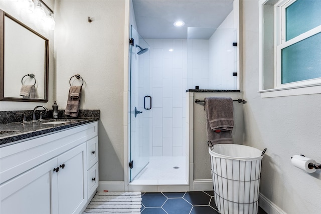 bathroom with tile patterned flooring, vanity, and walk in shower