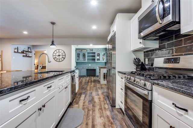 kitchen featuring sink, white cabinetry, tasteful backsplash, decorative light fixtures, and appliances with stainless steel finishes