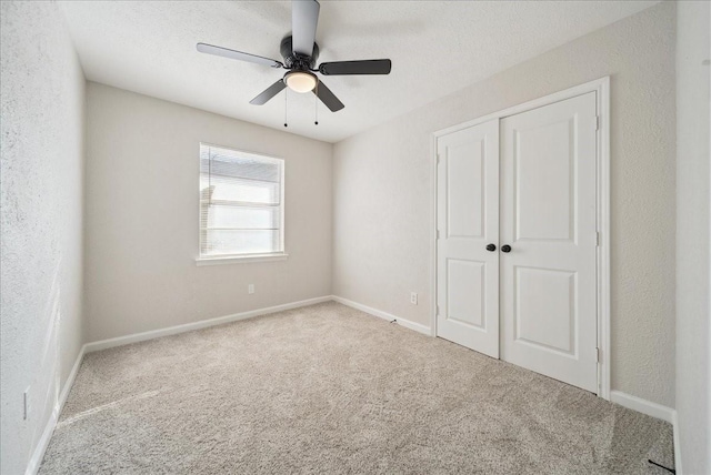 unfurnished bedroom featuring a textured wall, a closet, and carpet