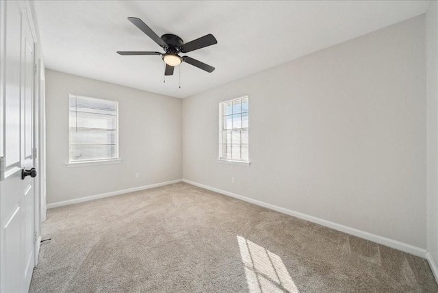 spare room featuring carpet, baseboards, and a ceiling fan