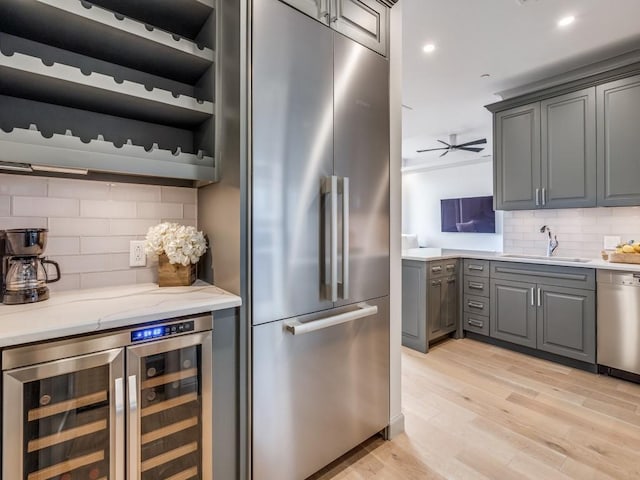 kitchen featuring sink, gray cabinetry, tasteful backsplash, appliances with stainless steel finishes, and beverage cooler