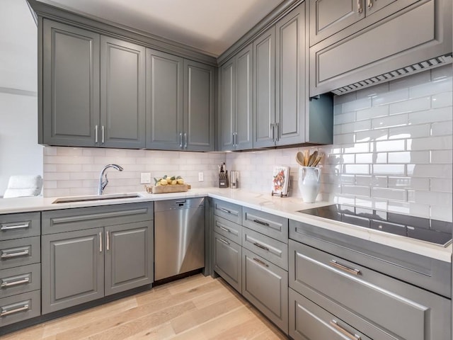 kitchen featuring sink, stainless steel dishwasher, black electric stovetop, light hardwood / wood-style floors, and backsplash