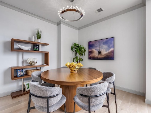 dining area featuring crown molding and light hardwood / wood-style flooring