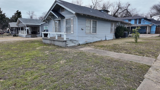 bungalow-style home featuring a front yard and central AC unit