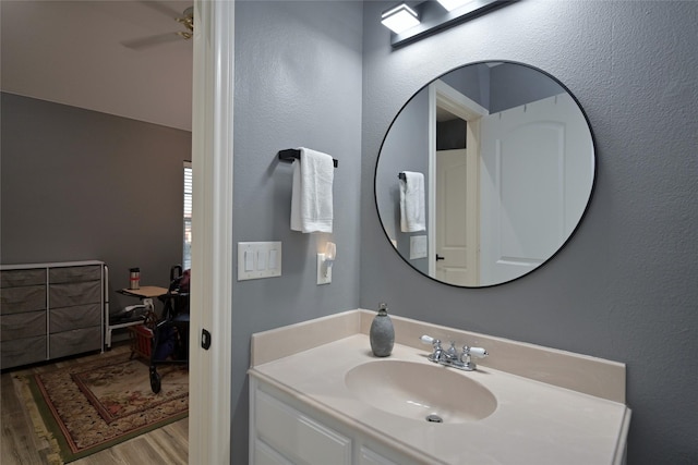 bathroom featuring ceiling fan, wood-type flooring, and vanity