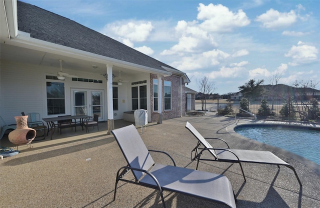 view of swimming pool featuring ceiling fan and a patio