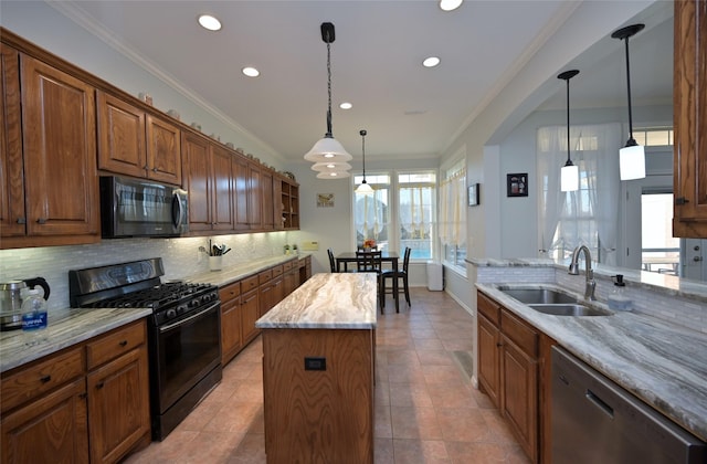 kitchen with sink, black appliances, light stone countertops, a kitchen island, and decorative light fixtures