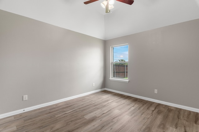 empty room with ceiling fan, high vaulted ceiling, and light hardwood / wood-style flooring