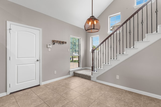 tiled entrance foyer featuring high vaulted ceiling and a healthy amount of sunlight