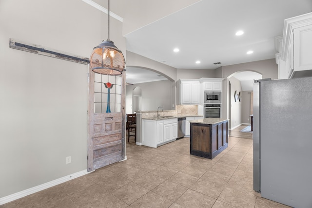 kitchen with pendant lighting, white cabinetry, sink, a center island, and stainless steel appliances