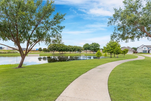 surrounding community with a water view and a yard