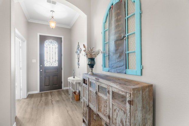 entryway featuring crown molding and light wood-type flooring