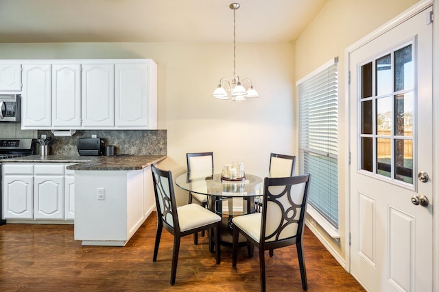 dining area featuring an inviting chandelier and dark hardwood / wood-style floors