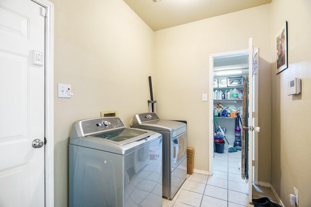 washroom with separate washer and dryer and light tile patterned floors