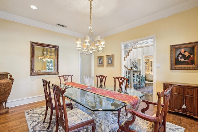 dining room featuring an inviting chandelier, ornamental molding, and dark hardwood / wood-style flooring