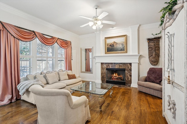 living room featuring dark wood-type flooring, ceiling fan, ornamental molding, and a premium fireplace