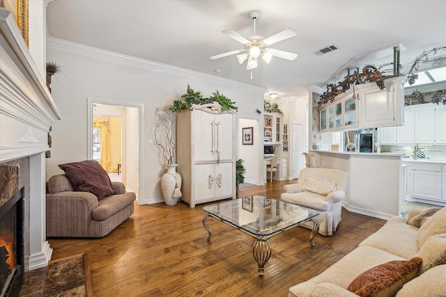 living room featuring crown molding, wood-type flooring, and ceiling fan