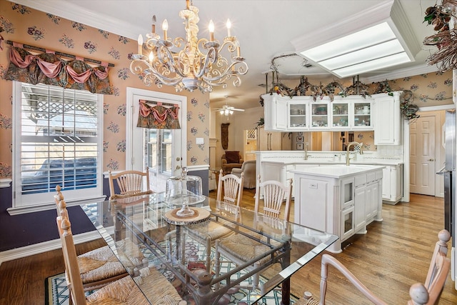 dining space featuring ornamental molding, sink, ceiling fan, and light hardwood / wood-style floors