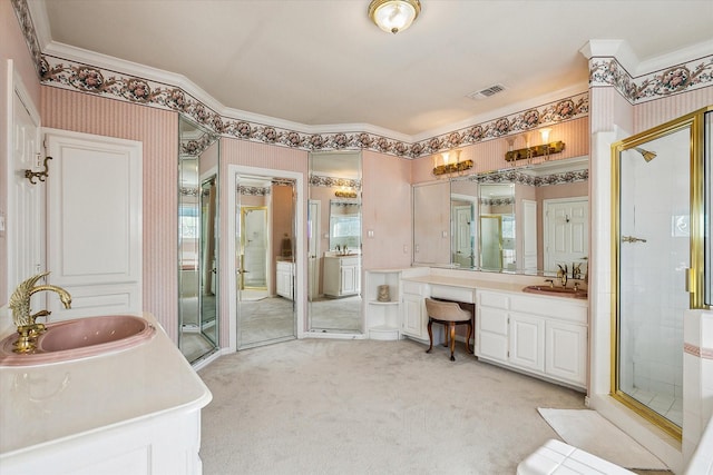 bathroom with a shower with door, vanity, and crown molding