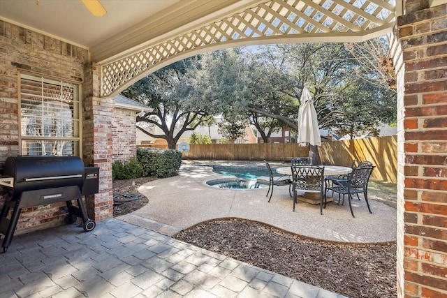 view of patio / terrace featuring an in ground hot tub and a grill