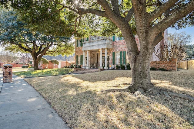 view of front of home with a front yard and a balcony