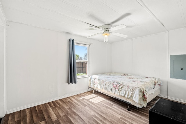 bedroom featuring hardwood / wood-style flooring, electric panel, and ceiling fan