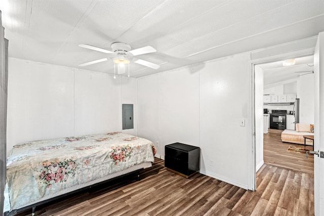 bedroom with hardwood / wood-style flooring, ceiling fan, and electric panel