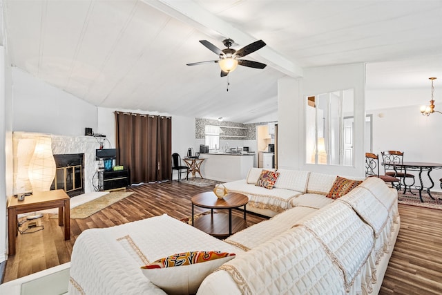 living room with hardwood / wood-style flooring, a premium fireplace, ceiling fan with notable chandelier, and vaulted ceiling with beams