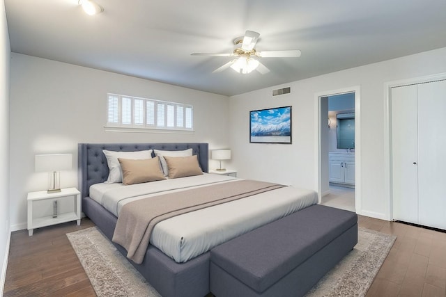 bedroom with ensuite bathroom, dark hardwood / wood-style floors, and ceiling fan