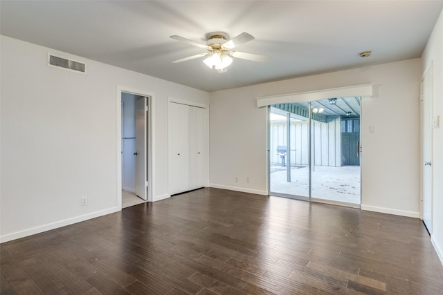 empty room with dark hardwood / wood-style flooring and ceiling fan