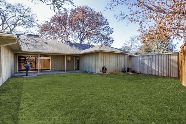 back of property with a yard and central air condition unit