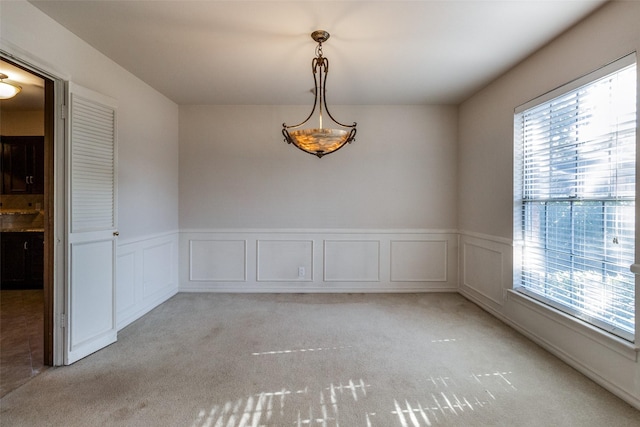 spare room featuring light carpet