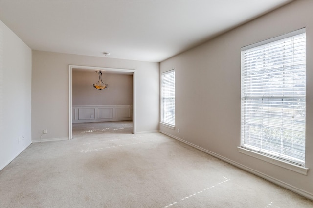 unfurnished room featuring a healthy amount of sunlight and light colored carpet