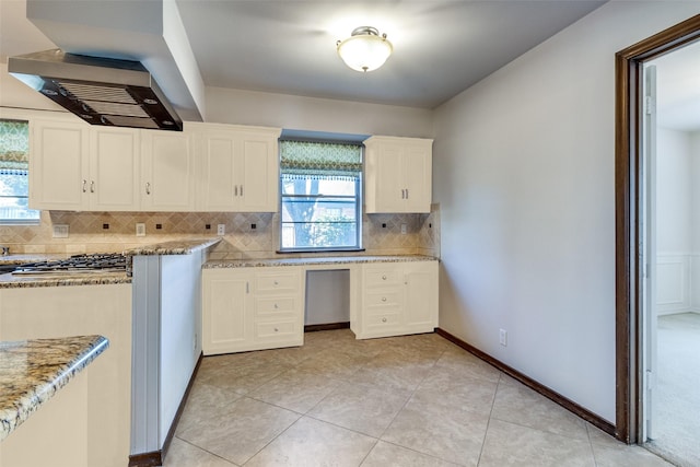 kitchen with white cabinetry, light tile patterned floors, tasteful backsplash, and light stone countertops