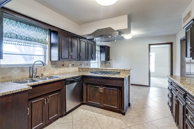 kitchen featuring sink, appliances with stainless steel finishes, range hood, light stone counters, and tasteful backsplash