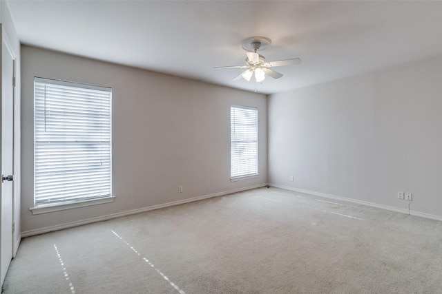 carpeted spare room with ceiling fan