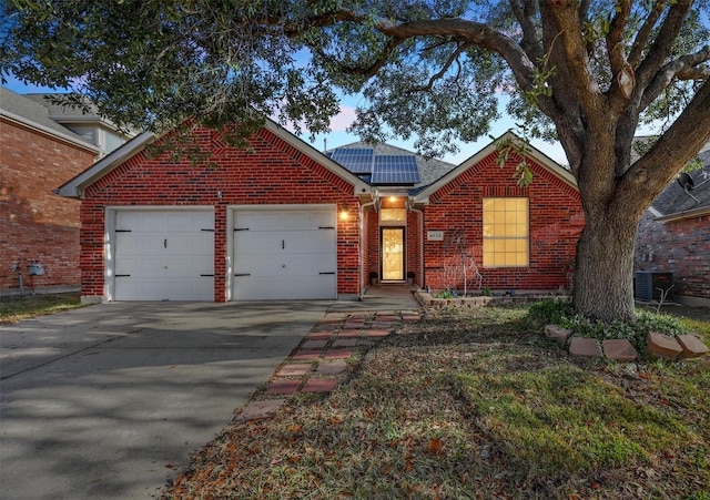 front facade featuring a garage, central AC, and solar panels