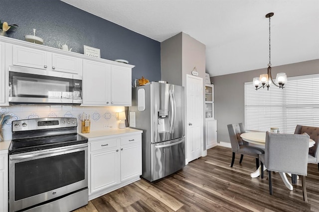 kitchen featuring white cabinetry, pendant lighting, vaulted ceiling, and appliances with stainless steel finishes