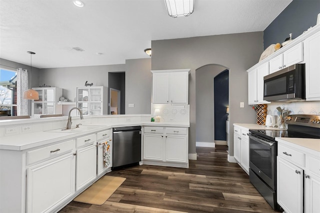 kitchen with stainless steel appliances, white cabinetry, sink, and backsplash