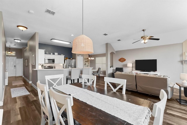 dining space with dark hardwood / wood-style floors and ceiling fan with notable chandelier