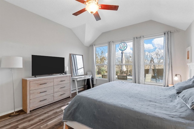 bedroom featuring ceiling fan, lofted ceiling, dark hardwood / wood-style flooring, and multiple windows