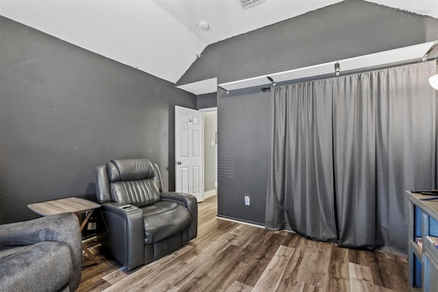 living area with hardwood / wood-style floors and vaulted ceiling