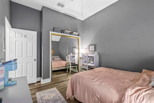 bedroom with dark hardwood / wood-style flooring and a closet