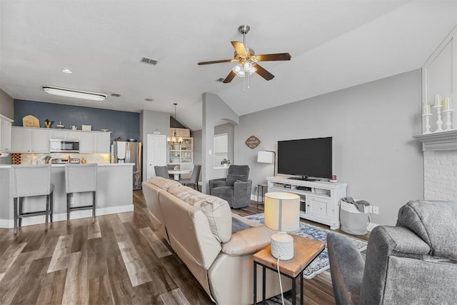 living room with lofted ceiling, dark hardwood / wood-style floors, and ceiling fan with notable chandelier