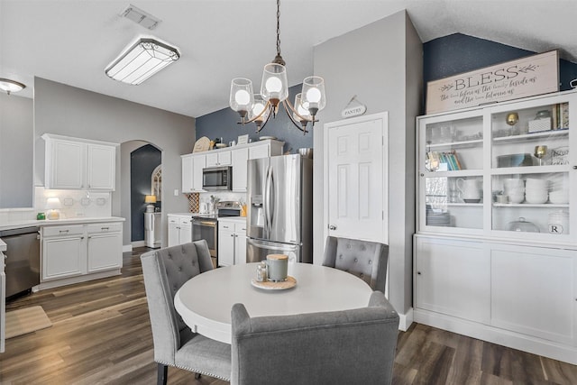 dining space with lofted ceiling, dark hardwood / wood-style floors, and a notable chandelier